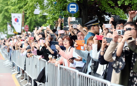 문재인 대통령이 10일 서울 여의도 국회의사당에서 취임선서를 마치고 국회대로를 지나는 가운데 시민들이 이를 지켜보고 있다.  사진공동취재단
